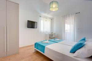 a white bedroom with a bed and a television at Villa nur 800 Meter zum Strand mit Meerblick, privatem Pool, BBQ und Spielplatz in Fažana +25 photos