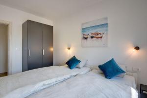 a bedroom with two beds with blue pillows at Ferienhaus mit Jacuzzi und Taverne mit Billard in Ližnjan