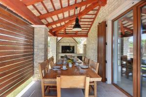 a wooden table in a patio with a dining room at Villa nur 800 Meter zum Strand mit Meerblick, privatem Pool, BBQ und Spielplatz in Fažana