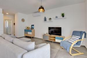 ein Wohnzimmer mit einem Sofa und einem TV in der Unterkunft Ferienwohnung mit Meerblick, nur 500 Meter zum Strand in Medulin
