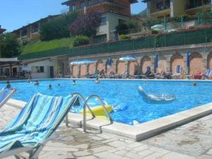 duży basen ze zjeżdżalniami i osobami w nim w obiekcie Tignale - Appartement VISTA BLU 107 - Ferienwohnung am Gardasee mieten w mieście Tignale
