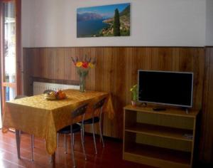 comedor con mesa y TV en Tignale - Appartement VISTA BLU 107 - Ferienwohnung am Gardasee mieten, en Tignale