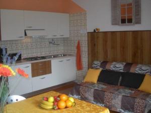 una cocina con sofá y mesa con fruta. en Tignale - Appartement VISTA BLU 107 - Ferienwohnung am Gardasee mieten, en Tignale