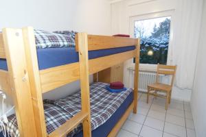 ノルトダイヒにあるBungalow Windstilleの小さな部屋の二段ベッド2台(椅子付)