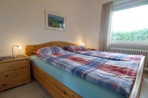 Un dormitorio con dos camas y una ventana. en Bungalow Tilla, en Norddeich