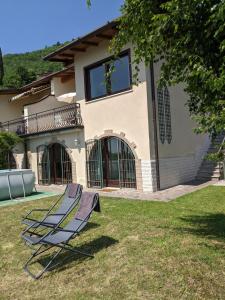 a pair of lawn chairs in front of a house at Ferienhaus mit Seeblick und Garten, Pool in ruhiger Lage von Tignale am Gardasee in Tignale