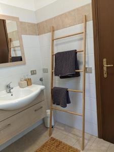a bathroom with a sink and a towel rack at Ferienhaus mit Seeblick und Garten, Pool in ruhiger Lage von Tignale am Gardasee in Tignale