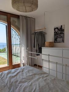 a bedroom with a bed and a large window at Ferienhaus mit Seeblick und Garten, Pool in ruhiger Lage von Tignale am Gardasee in Tignale