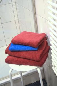 una pila de toallas rojas y azules sentadas en un taburete en Bungalow Windsbraut, en Norddeich