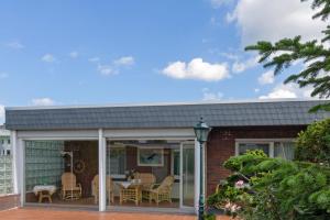 Una casa con un invernadero con mesa y sillas. en Bungalow Windsbraut, en Norddeich