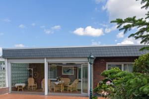 a house with a conservatory with a table and chairs at Bungalow Windsbraut in Norddeich