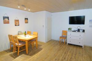 Un comedor con mesa y sillas y un televisor. en Bungalow Windsbraut, en Norddeich