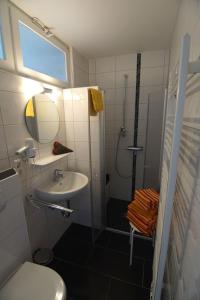 a bathroom with a toilet and a sink and a shower at Bungalow Hohes Riff in Norddeich