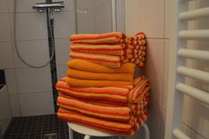 a stack of towels stacked on a toilet in a bathroom at Bungalow Hohes Riff in Norddeich