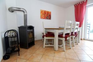 a dining room with a table and chairs and a stove at Haus Anne in Norddeich