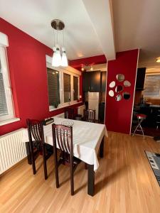 a kitchen and dining room with a white table and chairs at Miss apartman in Jagodina