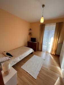 een slaapkamer met een bed, een tafel en een televisie bij Miss apartman in Jagodina