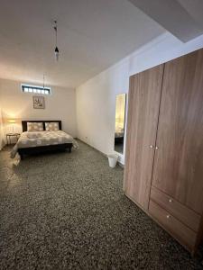 ein Schlafzimmer mit einem Bett und einem großen Holzschrank in der Unterkunft Apartamento Estudio Com Entrada Privada in Arrentela