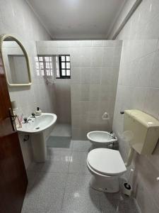 ein weißes Bad mit einem WC und einem Waschbecken in der Unterkunft Apartamento Estudio Com Entrada Privada in Arrentela