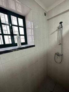 eine Dusche im Bad mit Fenster in der Unterkunft Apartamento Estudio Com Entrada Privada in Arrentela