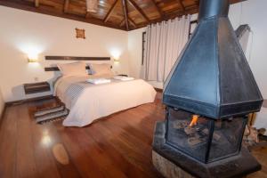 um quarto com uma cama e um fogão numa sala em Pousada Serra Vista em Gonçalves