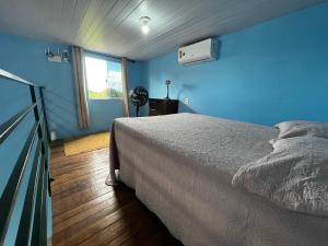 a blue bedroom with a bed and a window at Loft com vista para as montanhas in Chapada dos Guimarães