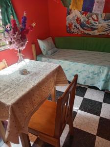 Una habitación con una mesa con un jarrón de flores. en TOGA GUEST HOUSE, en Port Antonio
