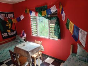 Zimmer mit einem Tisch und einem Fenster mit Gebetsflaggen in der Unterkunft TOGA GUEST HOUSE in Port Antonio