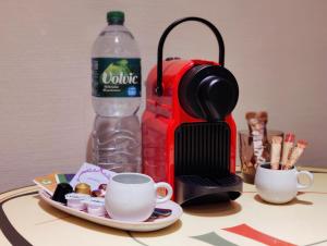 a coffee maker and a cup and a bottle of water at Spacious & comfortable guestrooms w private bathrooms near Koelnmesse & Lanxess Arena, free parking, highspeed WiFi in Cologne