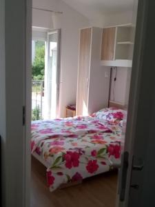 Un dormitorio con una cama con flores rosas. en L&L Apartments, en Povile