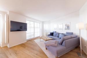 a living room with a couch and a tv at Ferienwohung BeachSide No 20 in Niendorf