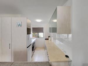 una cucina bianca con bancone e frigorifero di H2O Holiday Apartments Unit 12 a North Haven