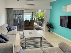 un soggiorno con divano e tavolo di H2O Holiday Apartments Unit 12 a North Haven