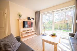 a living room with a couch and a large window at Bootsmann Gollendorf – mit eingezäuntem Garten in Gollendorf