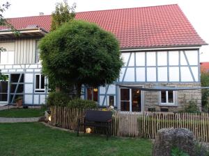 a house with a bench in front of a fence at Ferienwohnung Maierers Schaiere in Gammesfeld