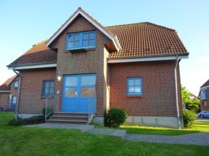 una casa de ladrillo rojo con puerta azul en Sonnenoase en Fehmarn