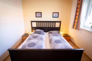 A bed or beds in a room at Große Terrasse und eingezäunter Garten – Lotsenhus