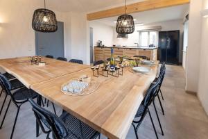 een grote houten tafel met stoelen in een keuken bij Freistehendes Landhaus Paco mit 2100qm eingezäuntes Grundstück, Kamin, Sauna und besuchen Sie die Alpakazucht in der Nachbarschaft in Blaufelden