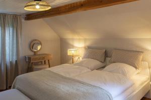 a bedroom with a large white bed and a mirror at Ferienhaus Pure Jagst, Traum-Lage am Fluss mit Kaminzimmer und Infrarot-Wärmekabine 