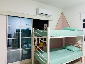 a bunk bed in a room with a window at Habitaciones y aptos Isabella in Santa Marta