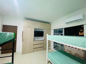 a room with a bunk bed and a kitchen at Habitaciones y aptos Isabella in Santa Marta