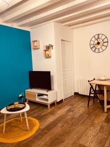 a living room with a tv and a table at Au porte du château in Chinon