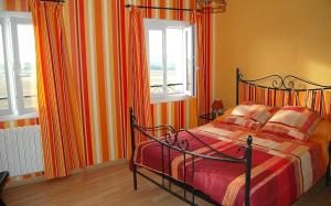een slaapkamer met een bed en 2 ramen bij Maison de 4 chambres avec vue sur la ville jacuzzi et jardin clos a Castelnau Montratier in Castelnau-de-Montratier
