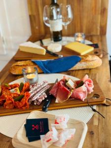 una mesa de madera con carne y comida. en Secrète loft, en Aucamville