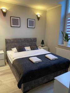 a bedroom with a large bed with two towels on it at Apartament Poranna Kawa in Rzeszów