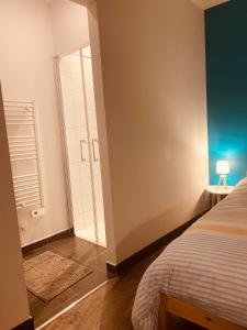 a bedroom with a bed and a door to a bathroom at Au porte du château in Chinon