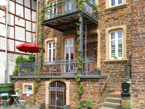 a brick building with a balcony and a table with an umbrella at Ferienhaus Moselmerle in Zell an der Mosel