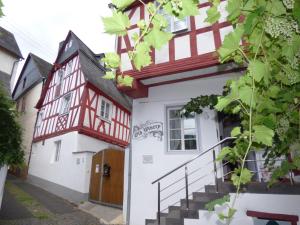 a house with a red and white building at Ferienhaus Old Winery in Briedel