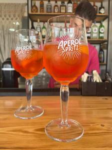 tres copas de vino sentadas sobre una mesa de madera en Anna Maria Apartments, en Kardamaina