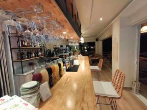 Anna Maria Apartments في كاردامينا: بار مع منضدة طويلة مع زجاجات من النبيذ